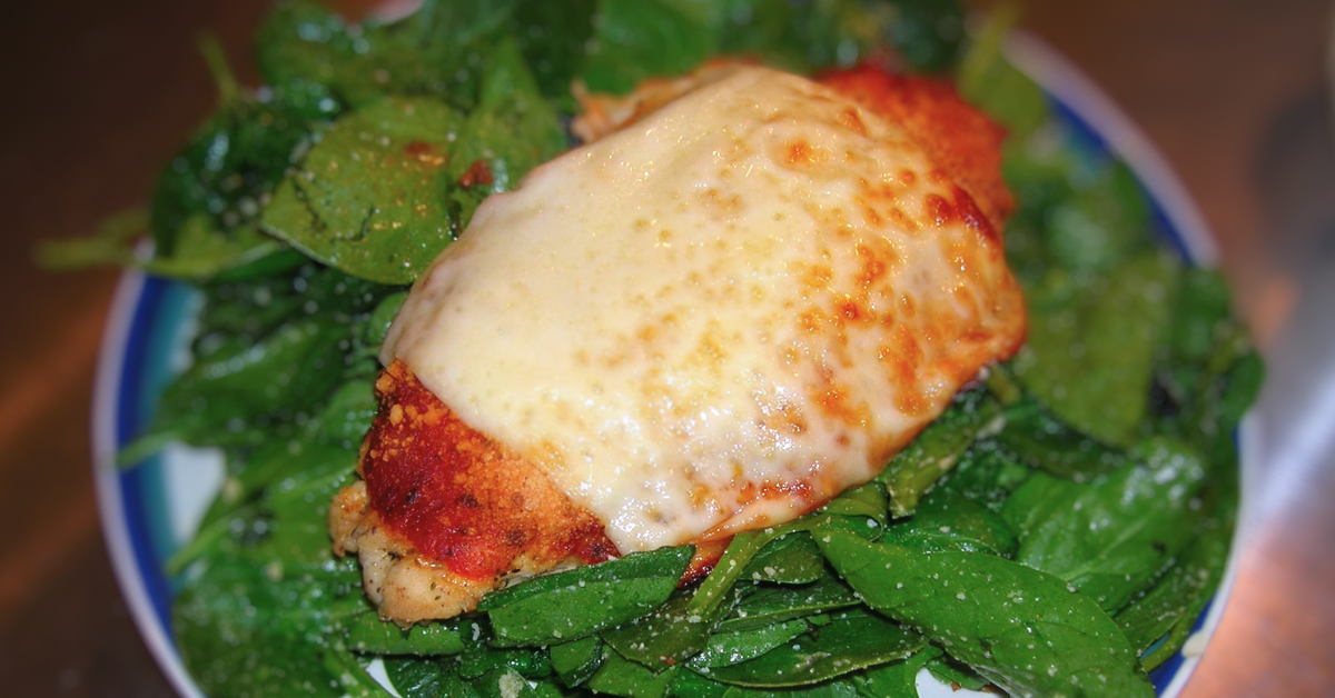 Parmesan chicken on a bed of spinach
